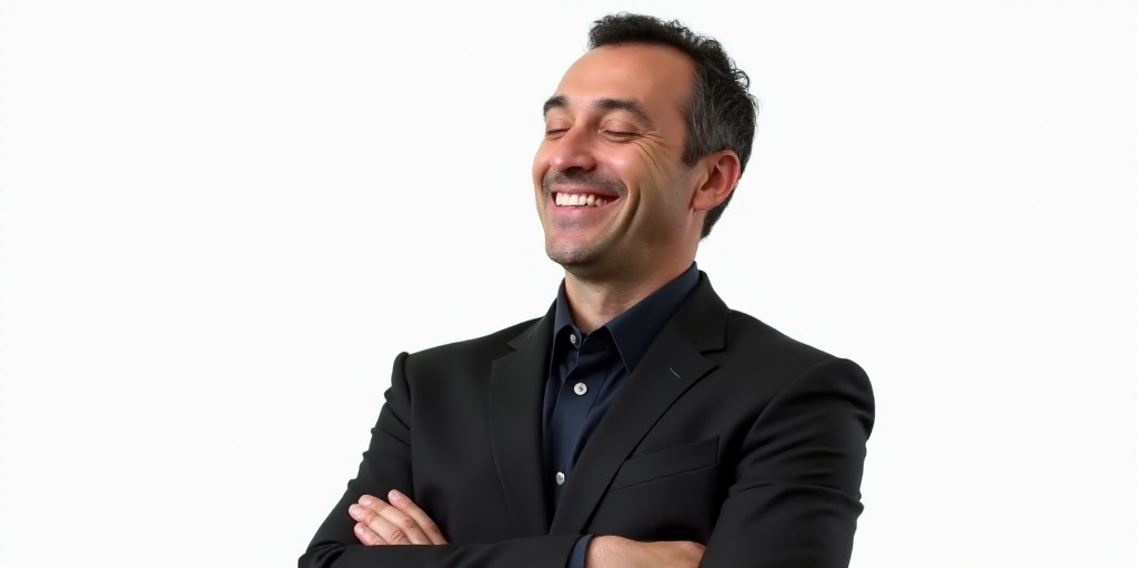 a man in a suit smiling for a picture with his arms crossed and his eyes closed, with a white backgr