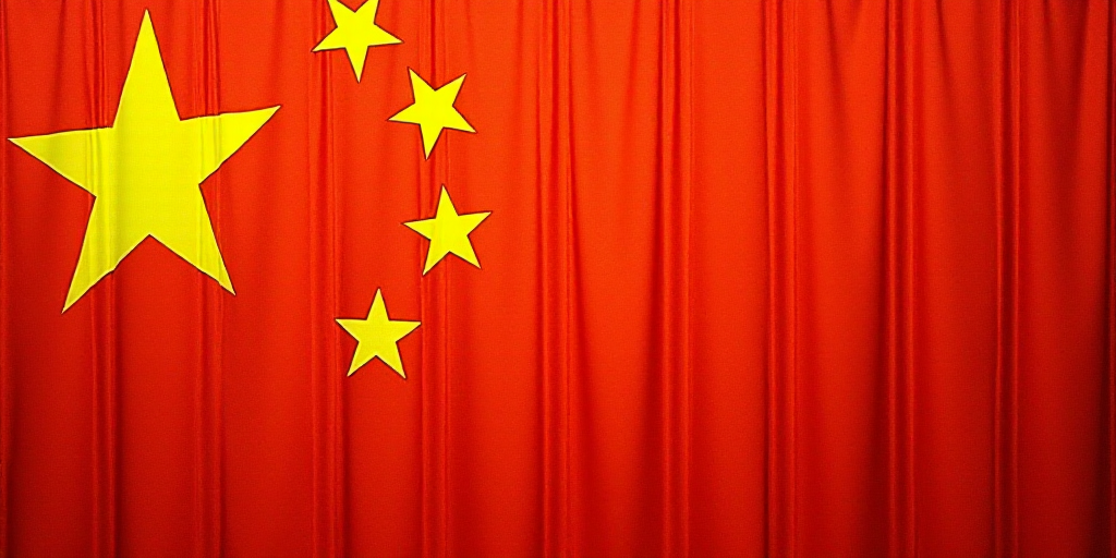 a close up of a flag with a red background and a yellow one with white stars on it and a red one wit