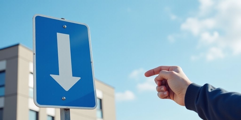 a blue and white sign with a pointing hand in front of a building with a sky background and a hand p