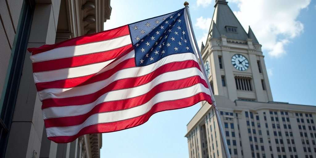 a large american flag flying in front of a building with a clock tower in the background and a build