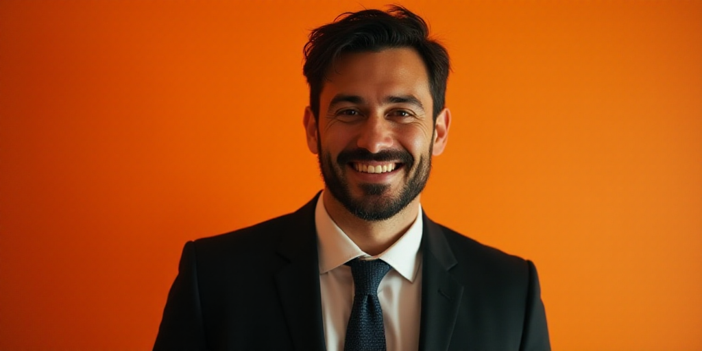 a man in a suit and tie is smiling for a picture with an orange background and a black and white pho