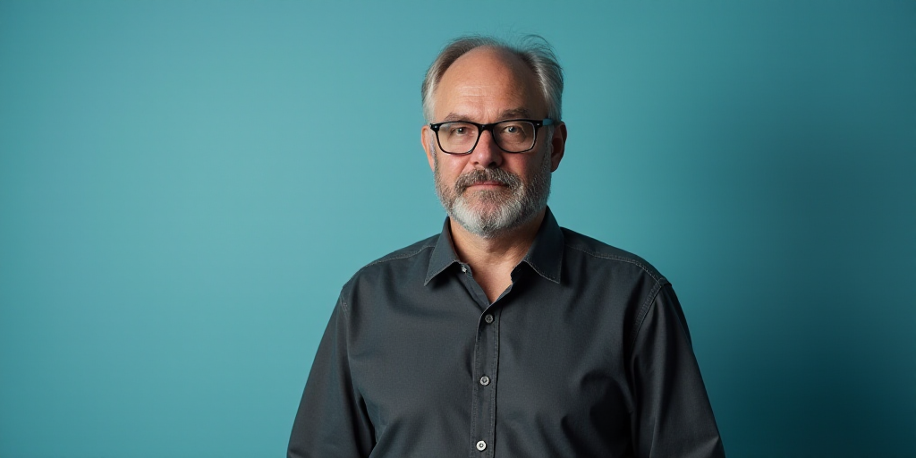 a man in glasses is standing in front of a blue background with a black and white photo of him, Edwa