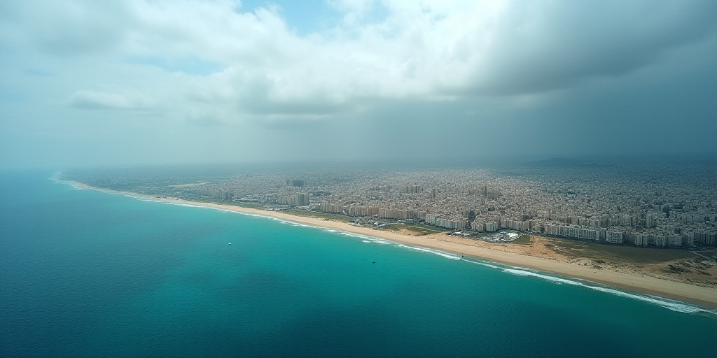 a city on a beach with a blue ocean and a cloudy sky above it and a blue ocean below it, Esaias Bour