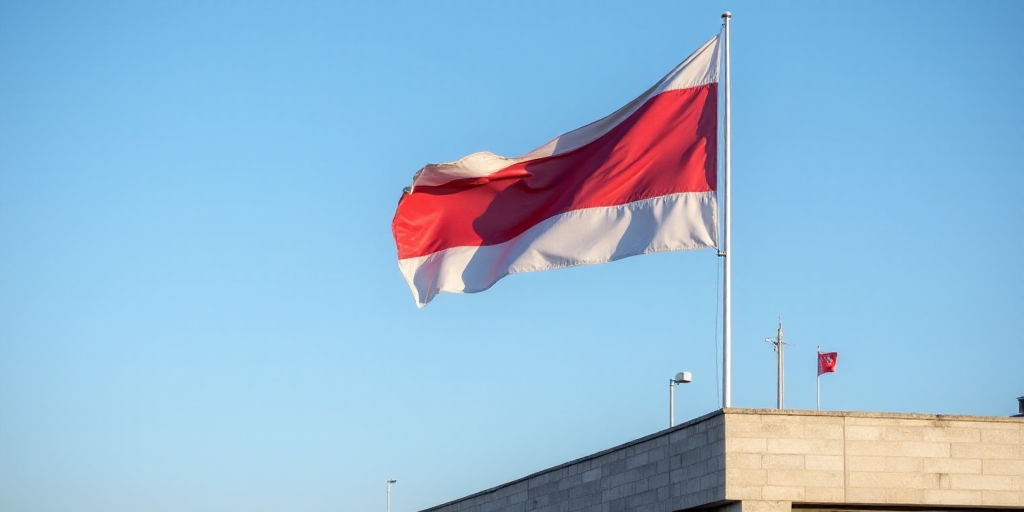 a flag flying in the wind on a clear day with a blue sky in the background and a building with a fla