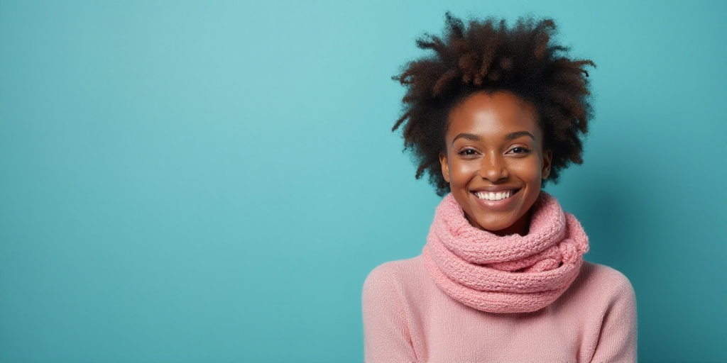 a woman with a scarf on her neck smiling at the camera with a blue background and a black and white