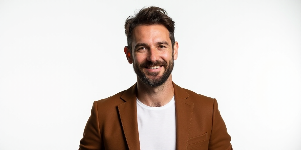 a man in a brown jacket and white shirt smiling at the camera with a white background and a white ba