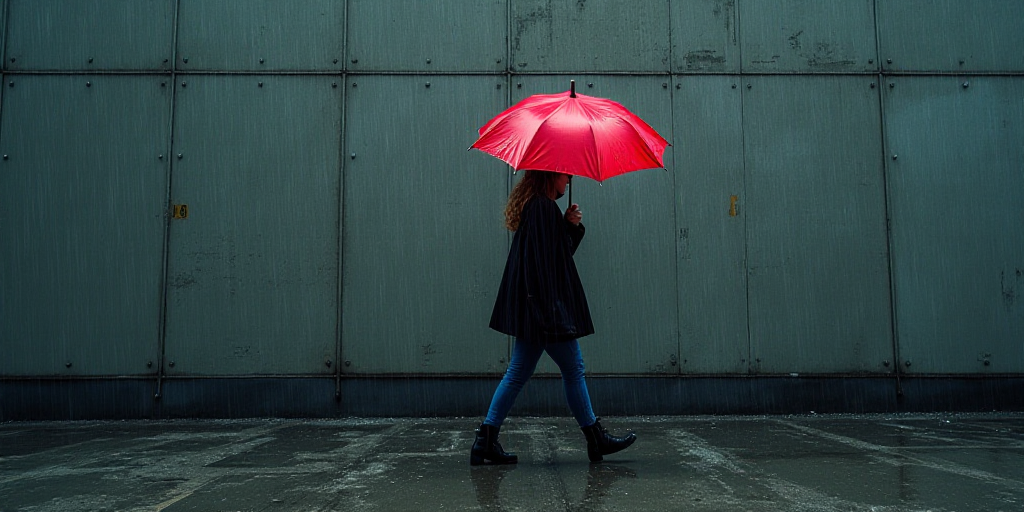 a woman walking past a wall with a red umbrella in front of it and a large display of stock prices,