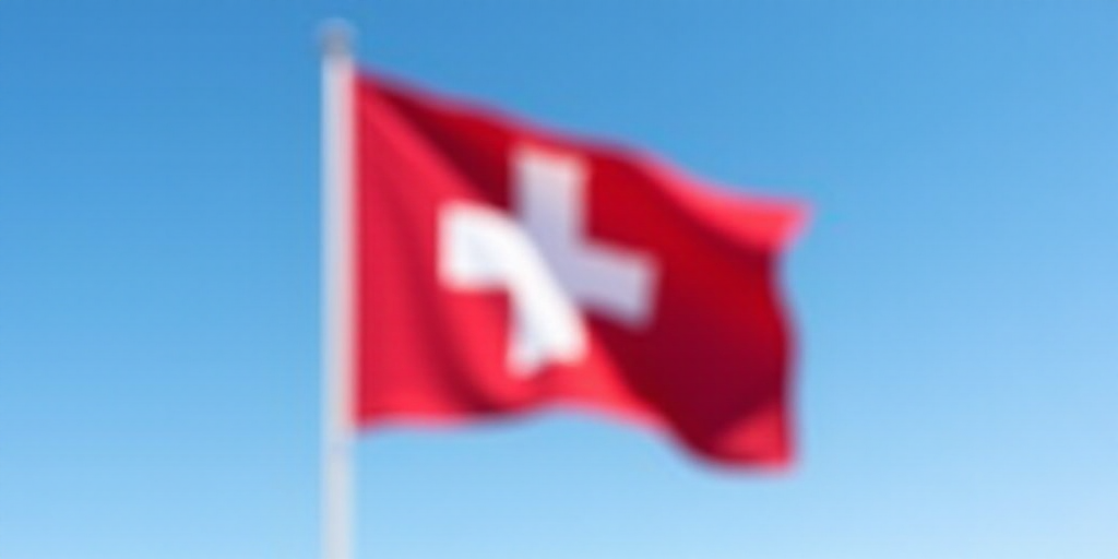 a swiss flag flying in the wind on a clear day with a blue sky in the background and a white cross o